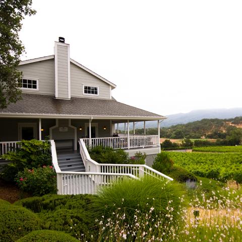 A view of the Arrowood Vineyards tasting room with stairs leading up to the porch.