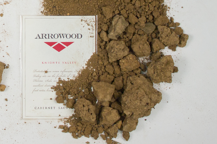 Arrowood Vineyard's  knights Valley Cabernet Sauvignon wine label on a white background with dirt artfully scattered around the label mostly to the right.